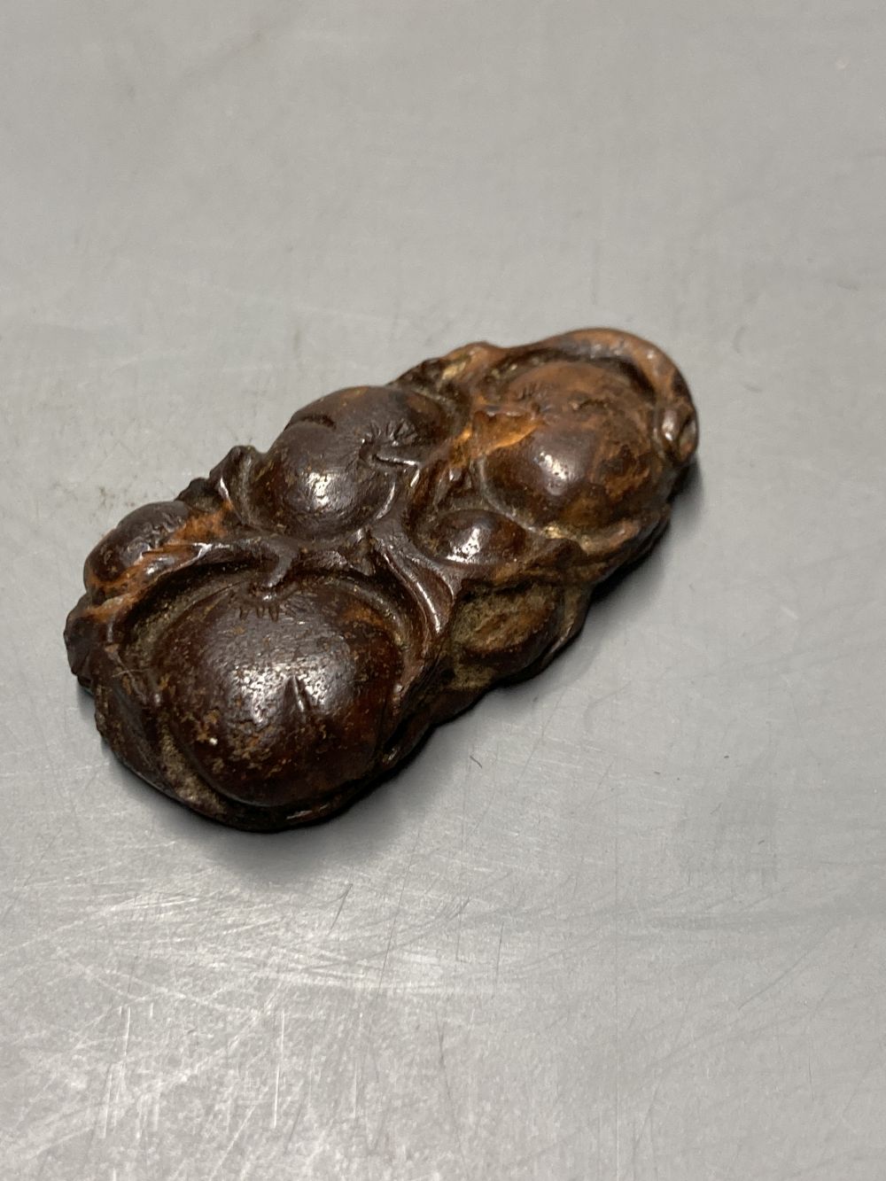 A Chinese carved Australian boulder opal pendant with flowers to the front and fruit to the back, 4.5cm, gross 17.1 grams.